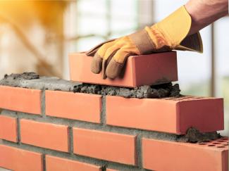 A hand showing brick layering construction